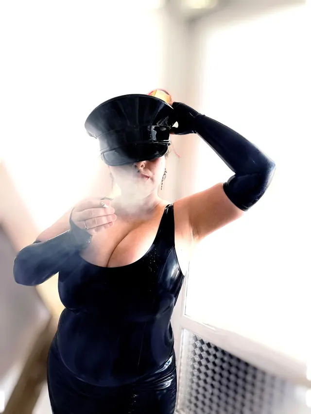 Back view of a black outfit and cap beside a bright window